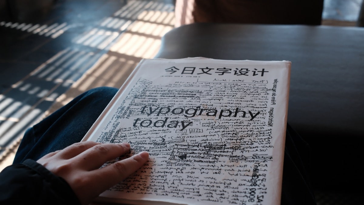 A person holding a book titled "typography today"